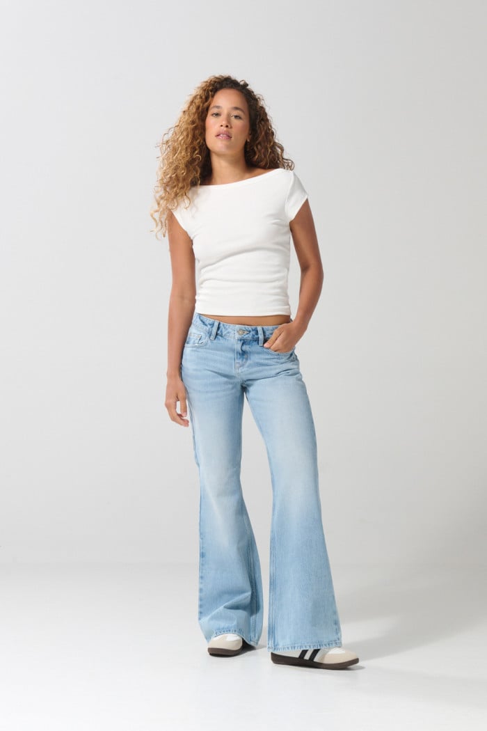 Jean flare azul claro con bota ancha, desgastes y tiro medio