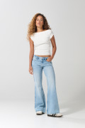 Jean flare azul claro con bota ancha, desgastes y tiro medio