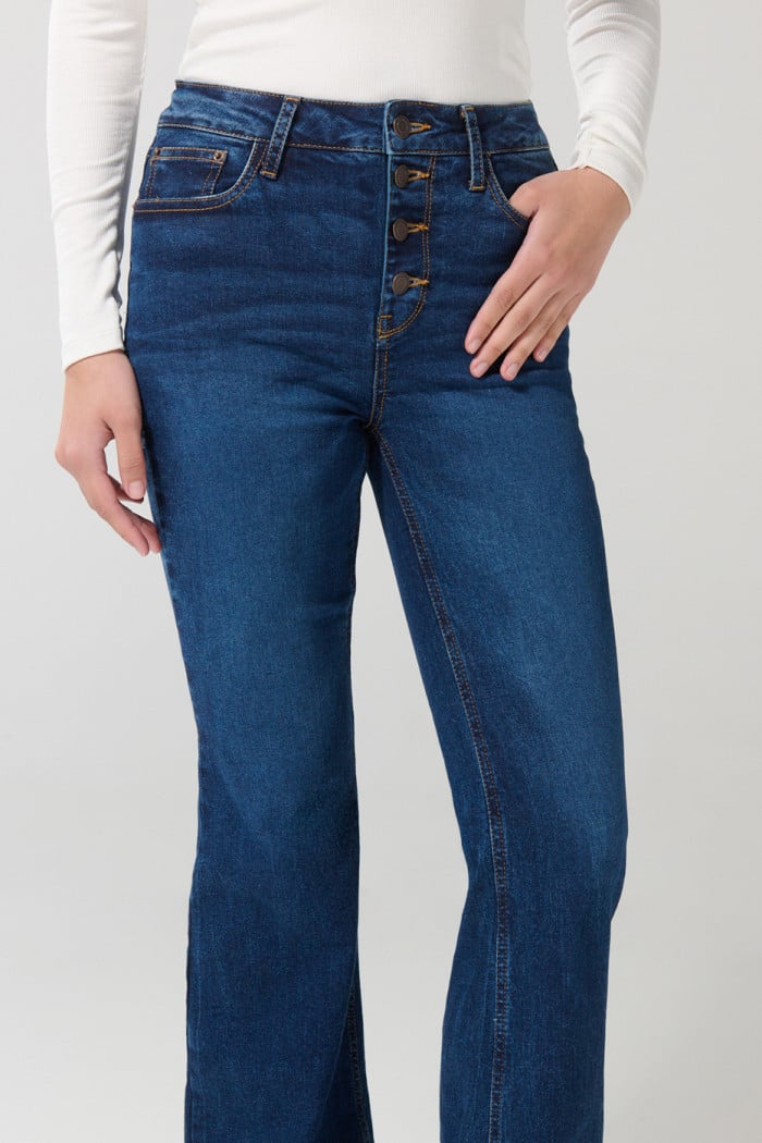 Jean azul oscuro flare con bota ancha, botones y tiro alto