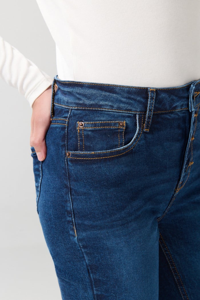 Jean azul oscuro flare con bota ancha, botones y tiro alto