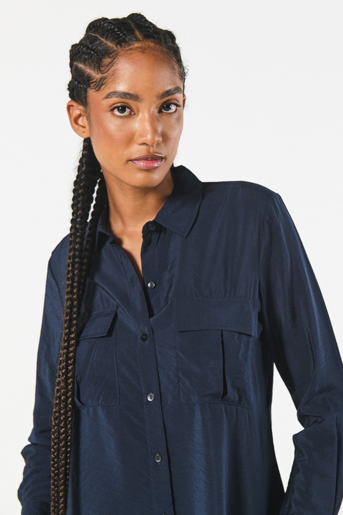Blusa manga larga unicolor con doble bolsillo en frente