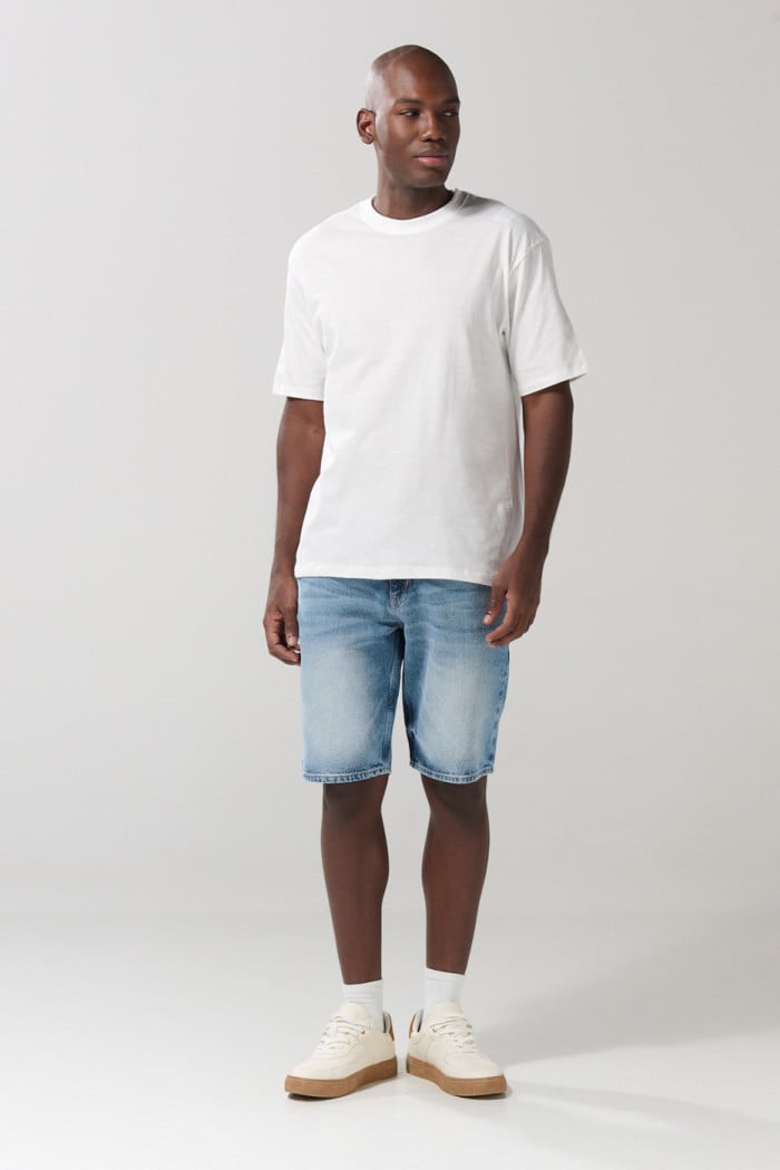 Bermuda en jean azul clara tipo slim con rotos y tiro bajo