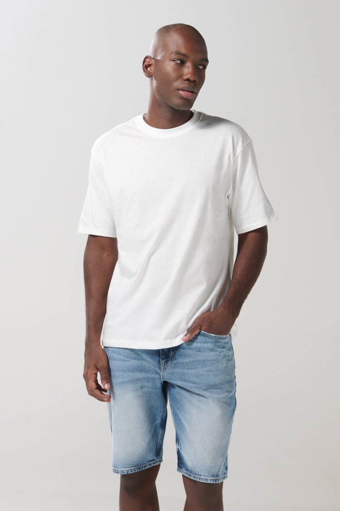 Bermuda en jean azul clara tipo slim con rotos y tiro bajo