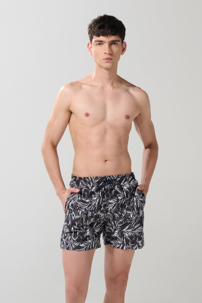 Bermuda negra playera con diseños de hojas blancas