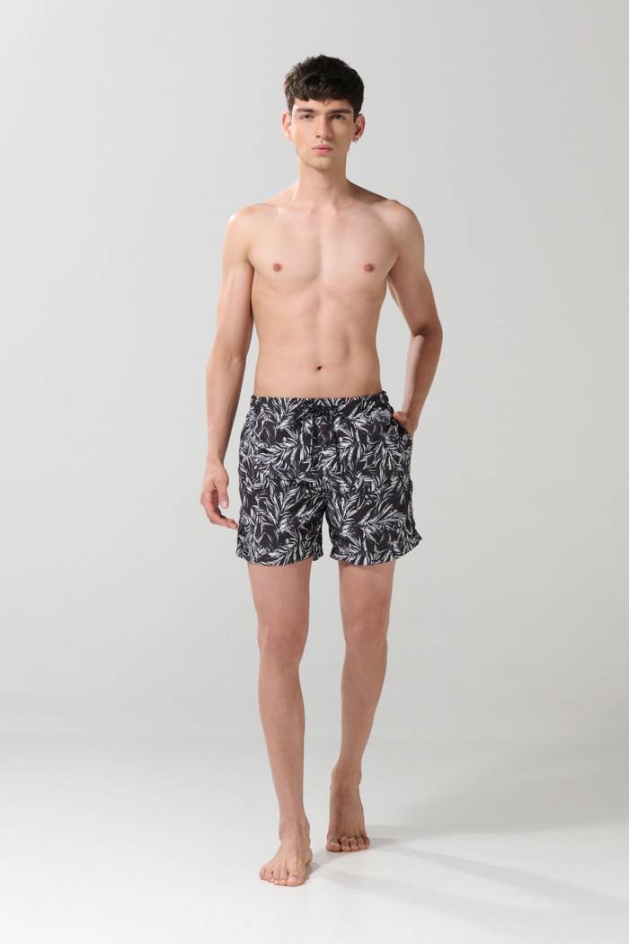 Bermuda negra playera con diseños de hojas blancas