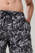 Bermuda negra playera con diseños de hojas blancas