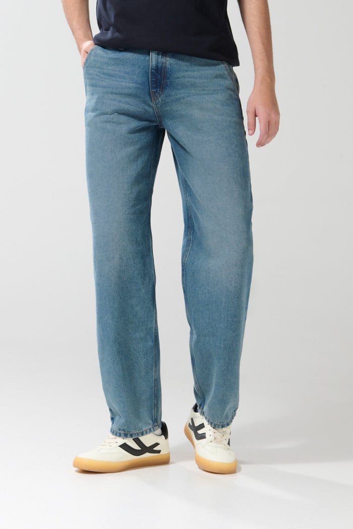 Jean tiro medio skater azul claro con desgastes y bota ancha