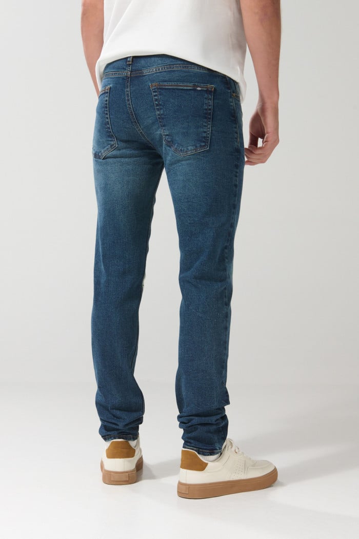 Jean azul oscuro slim con tiro bajo, rotos y parche interno