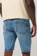 Bermuda slim tiro bajo en jean azul con rotos y diseños