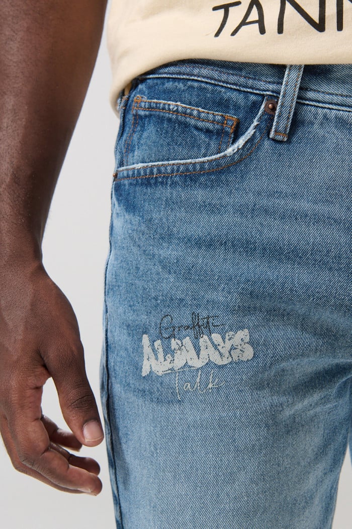 Bermuda slim tiro bajo en jean azul con rotos y diseños