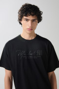 Camiseta negra cuello redondo oversize con diseño college
