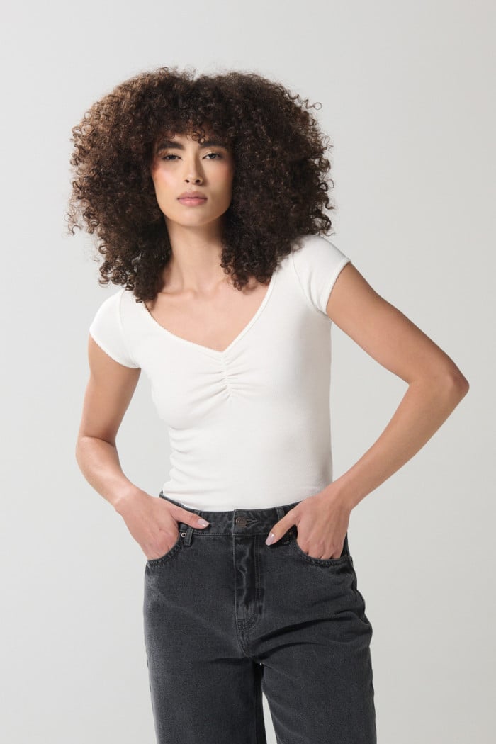 Camiseta unicolor con cuello V y recogido en frente
