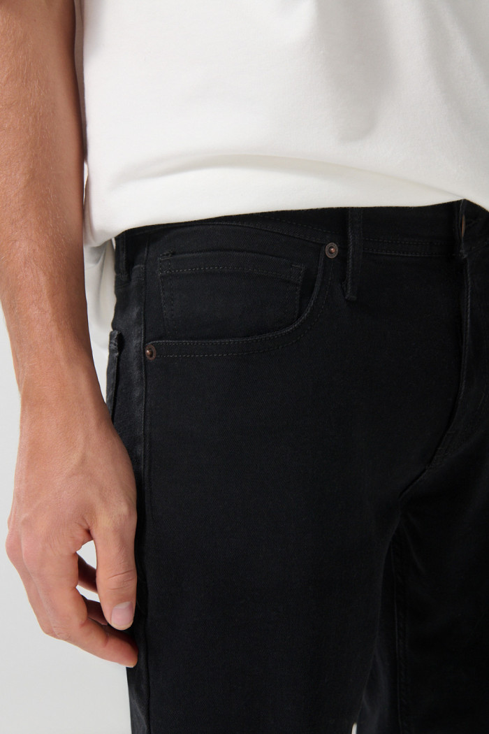 Jean slim negro con tiro bajo, ajuste ceñido y bolsillos