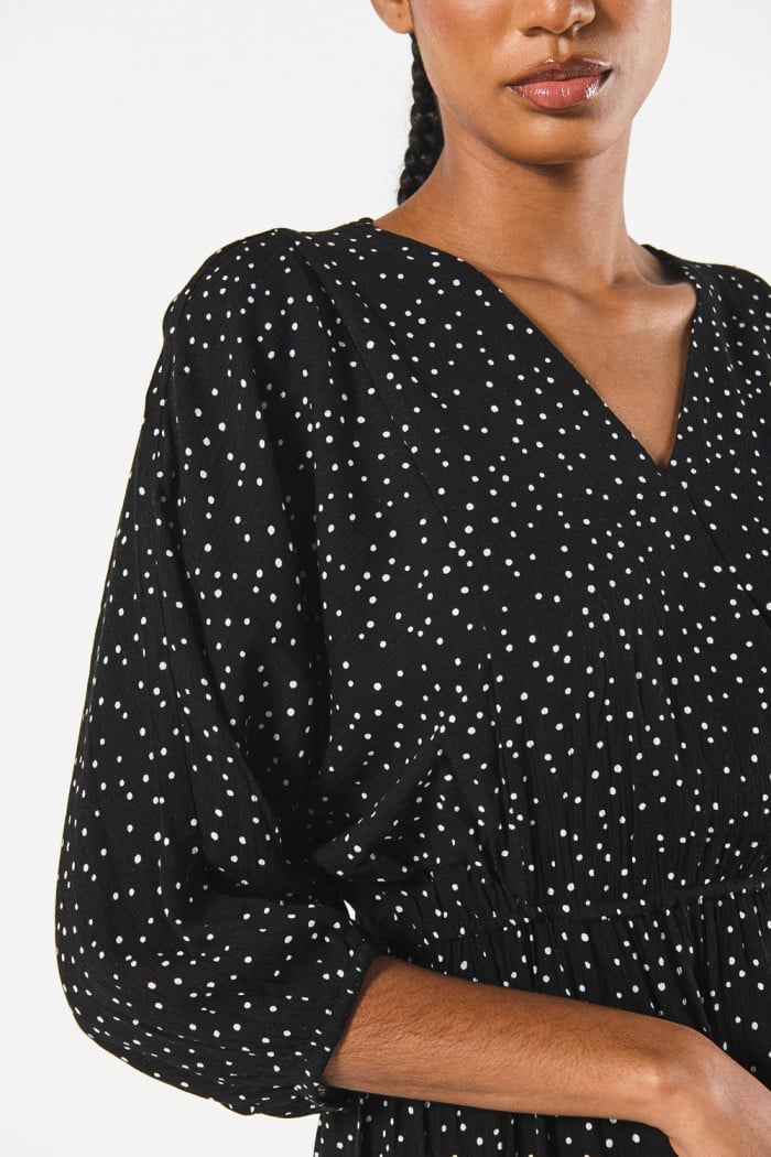 Vestido corto negro con escote cruzado y puntos estampados