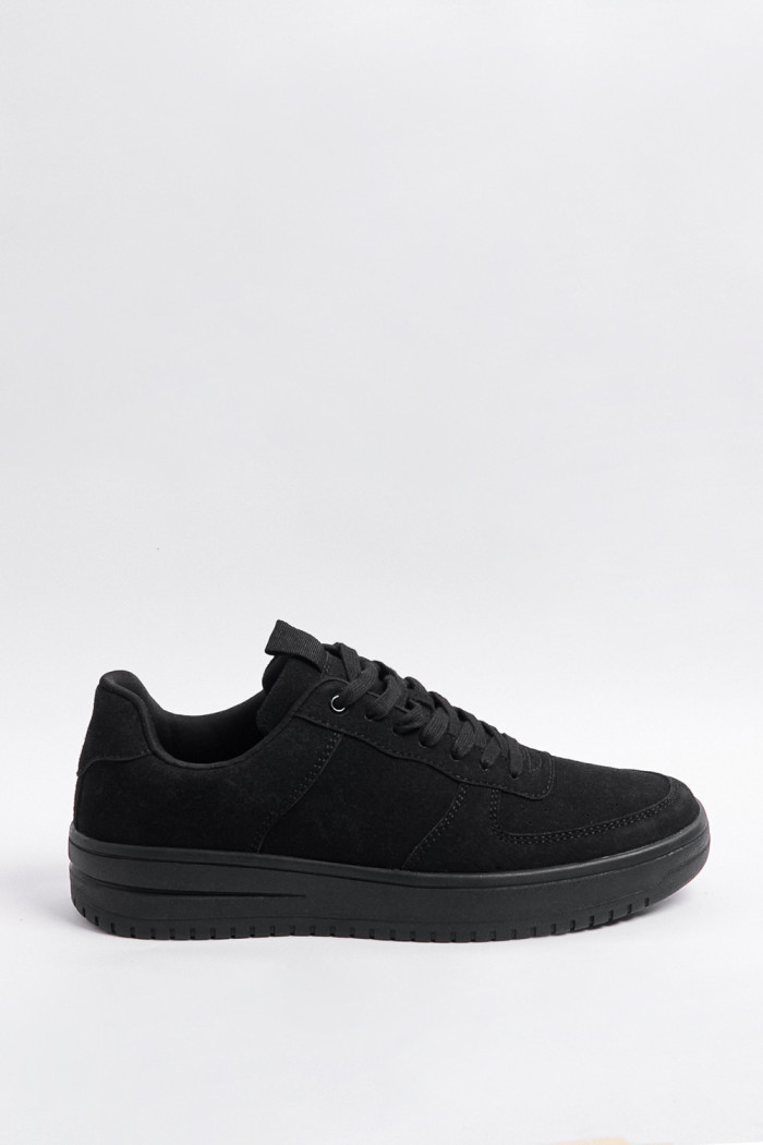 Tenis negros casuales con suelas planas y perforaciones