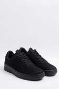 Tenis negros casuales con suelas planas y perforaciones