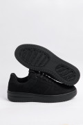 Tenis negros casuales con suelas planas y perforaciones