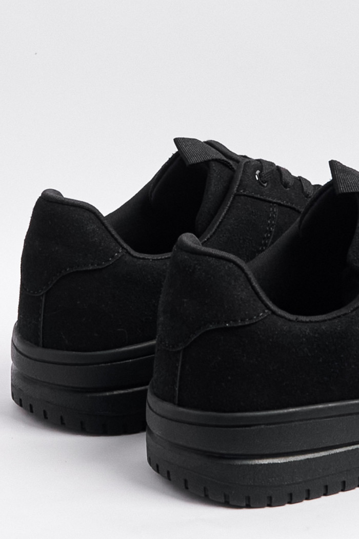 Tenis negros casuales con suelas planas y perforaciones