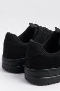 Tenis negros casuales con suelas planas y perforaciones
