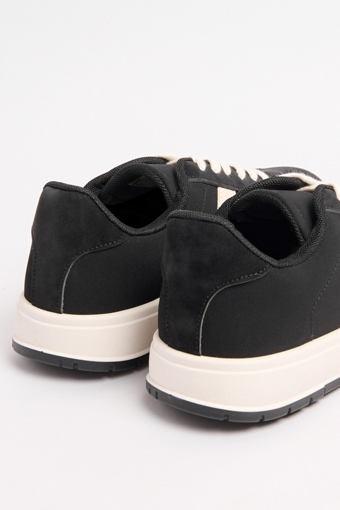 Tenis negros casuales con contrastes blancos laterales
