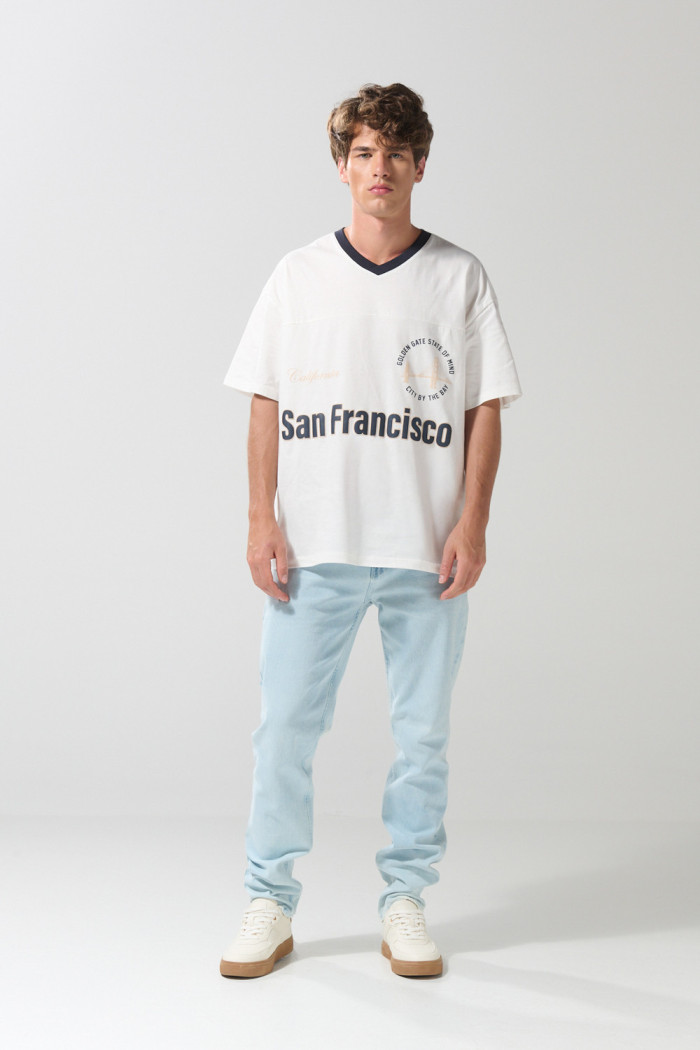 Camiseta oversize crema con cuello V y diseño college