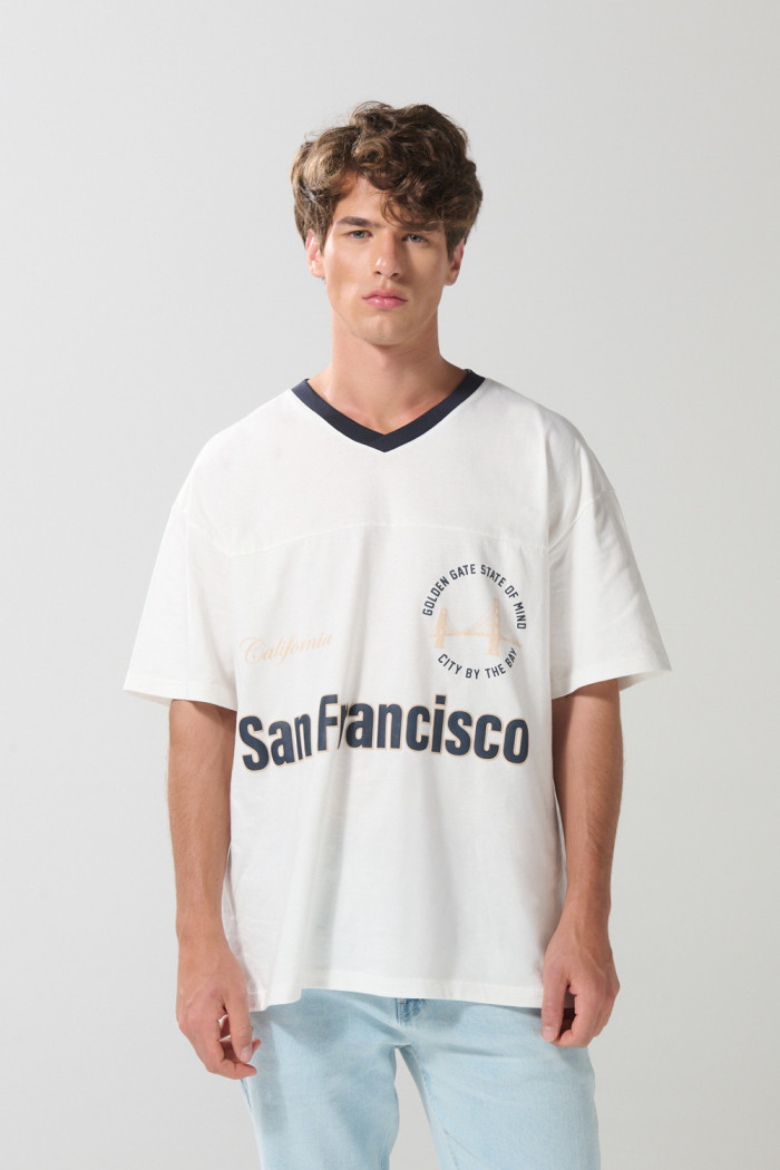 Camiseta oversize crema con cuello V y diseño college