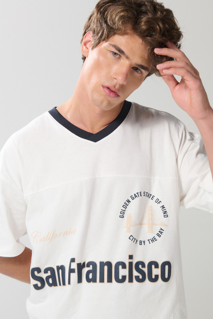 Camiseta oversize crema con cuello V y diseño college