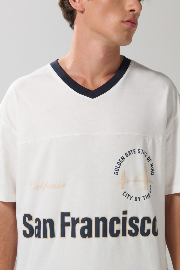 Camiseta oversize crema con cuello V y diseño college