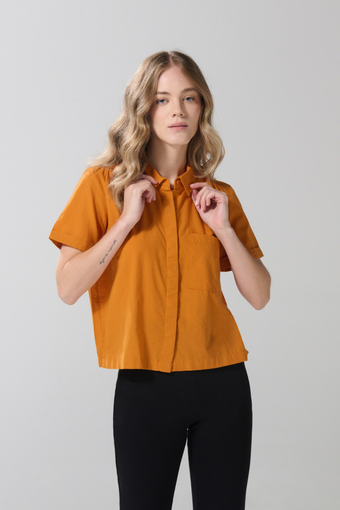 Blusa unicolor con bolsillo, manga corta y botones