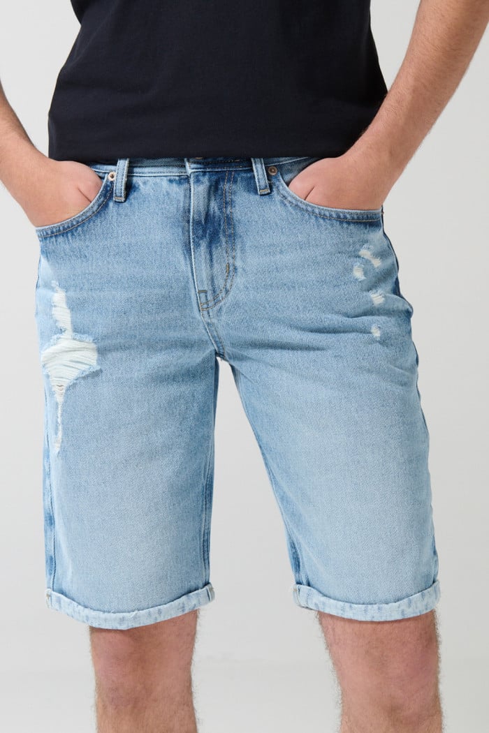 Bermuda slim azul en jean con tiro bajo y rotos delanteros