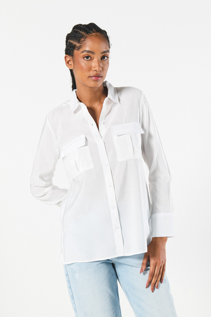 Blusa manga larga unicolor con doble bolsillo en frente