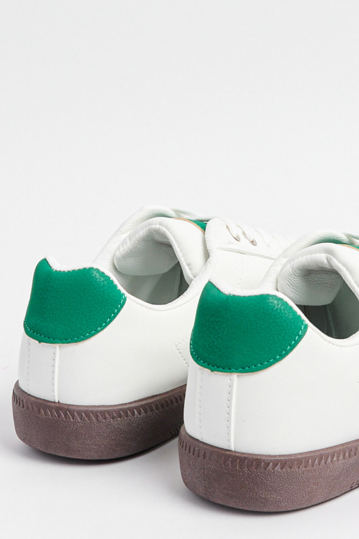 Tenis casuales blancos con contrastes verdes localizados