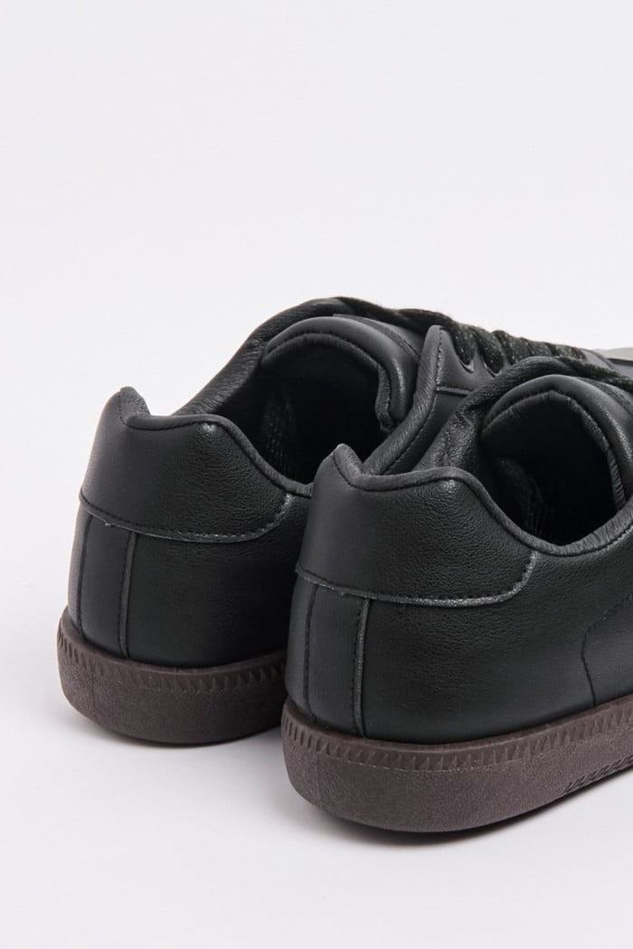 Tenis casuales negros con líneas verdes y suelas planas