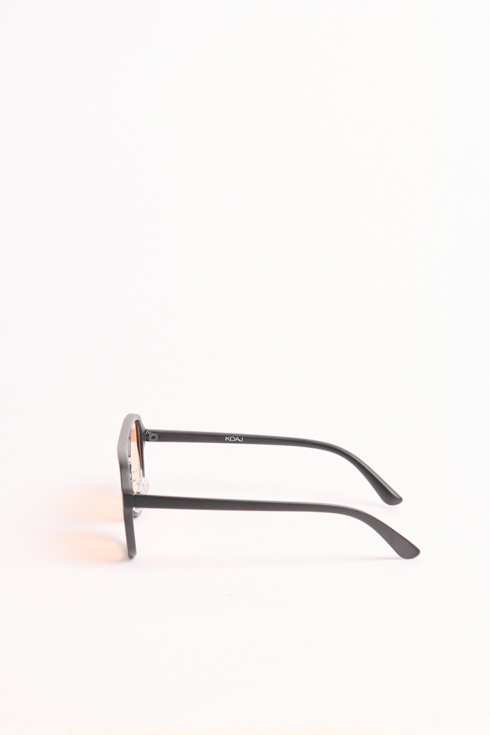 gafas de sol silueta piloto elaboradas en pasta negra con lente rojo.