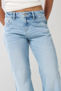 Jean flare azul claro con bota ancha, desgastes y tiro medio