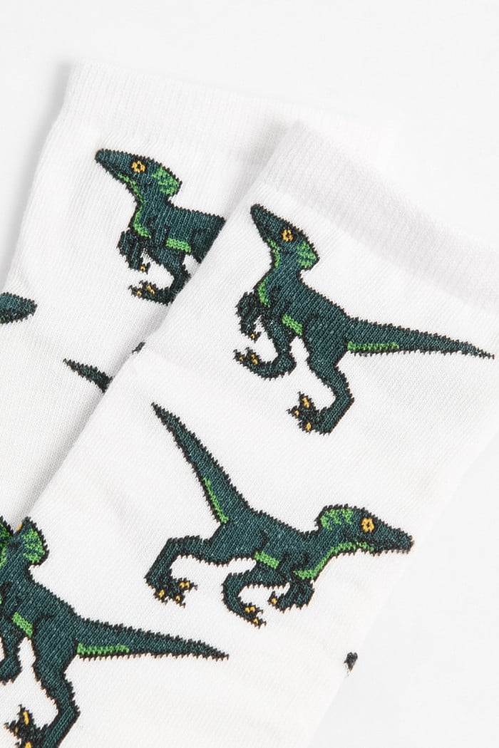 Medias cremas largas con diseños de dinosaurios
