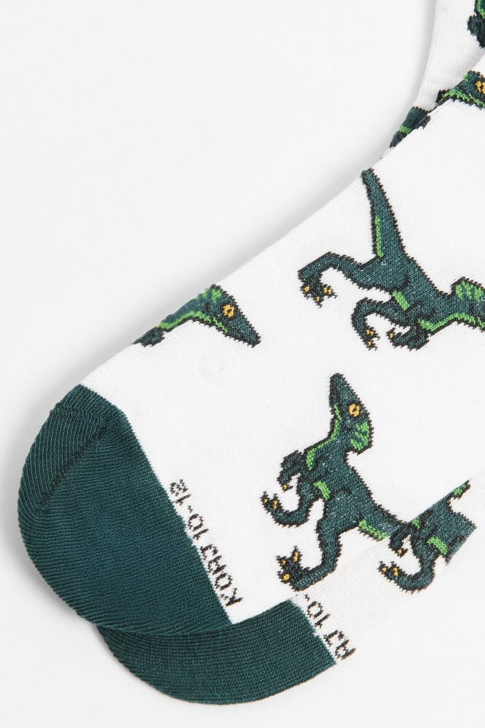 Medias cremas largas con diseños de dinosaurios