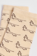 Medias kakis claras largas con diseños de perritos