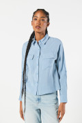 Blusa crop unicolor con manga larga y bolsillos delanteros