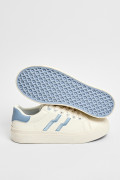 Tenis blancos casuales con contrastes azules y cordones