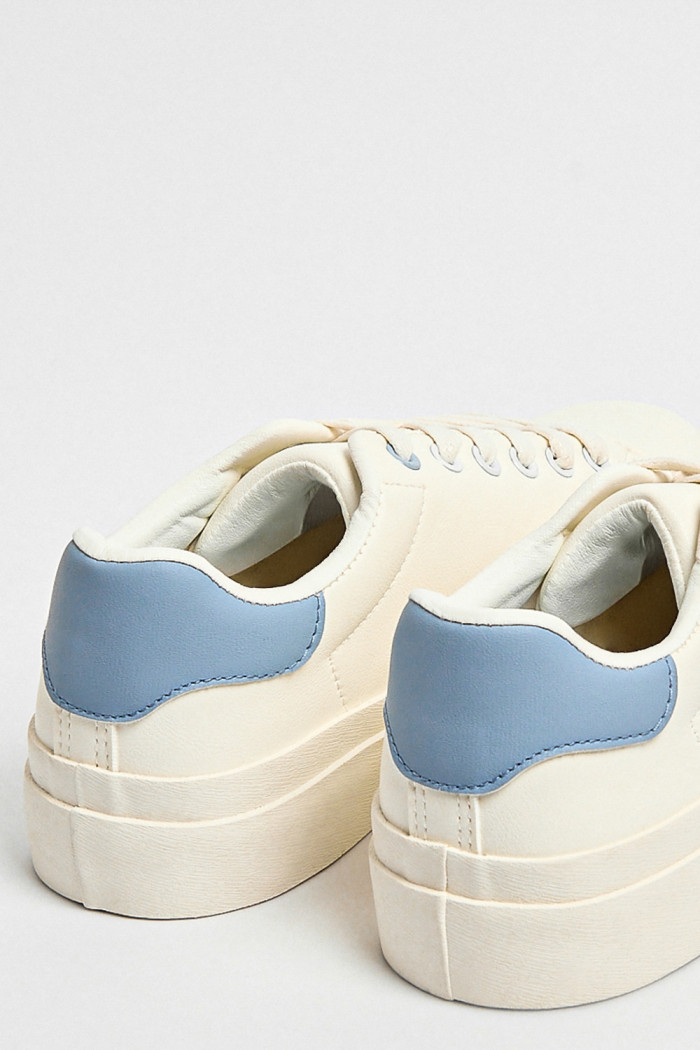 Tenis blancos casuales con contrastes azules y cordones