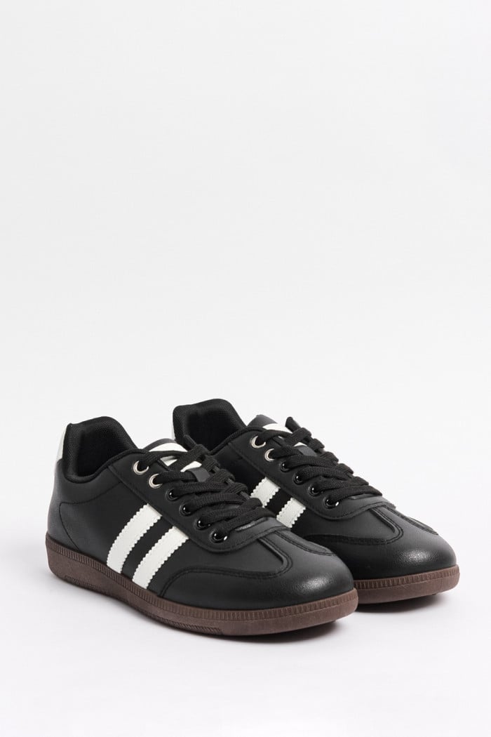 Tenis negros casuales con contrastes blancos localizados