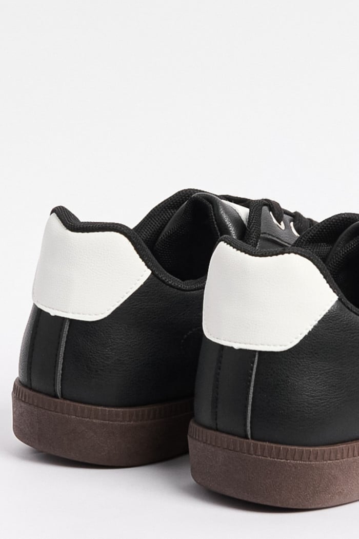 Tenis negros casuales con contrastes blancos localizados