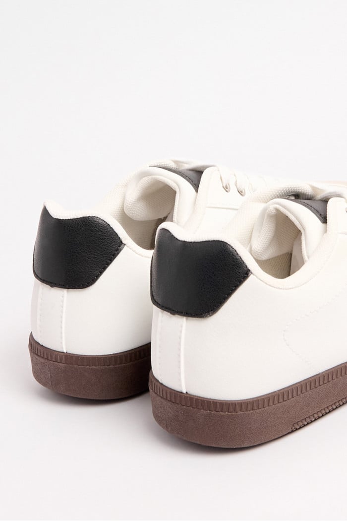 Tenis blancos casuales con contrastes negros y cortes