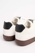 Tenis blancos casuales con contrastes negros y cortes