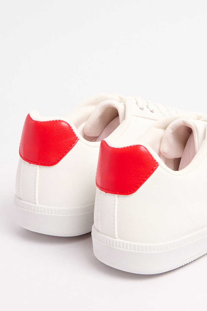 Tenis casuales blancos con contrastes rojos y cortes