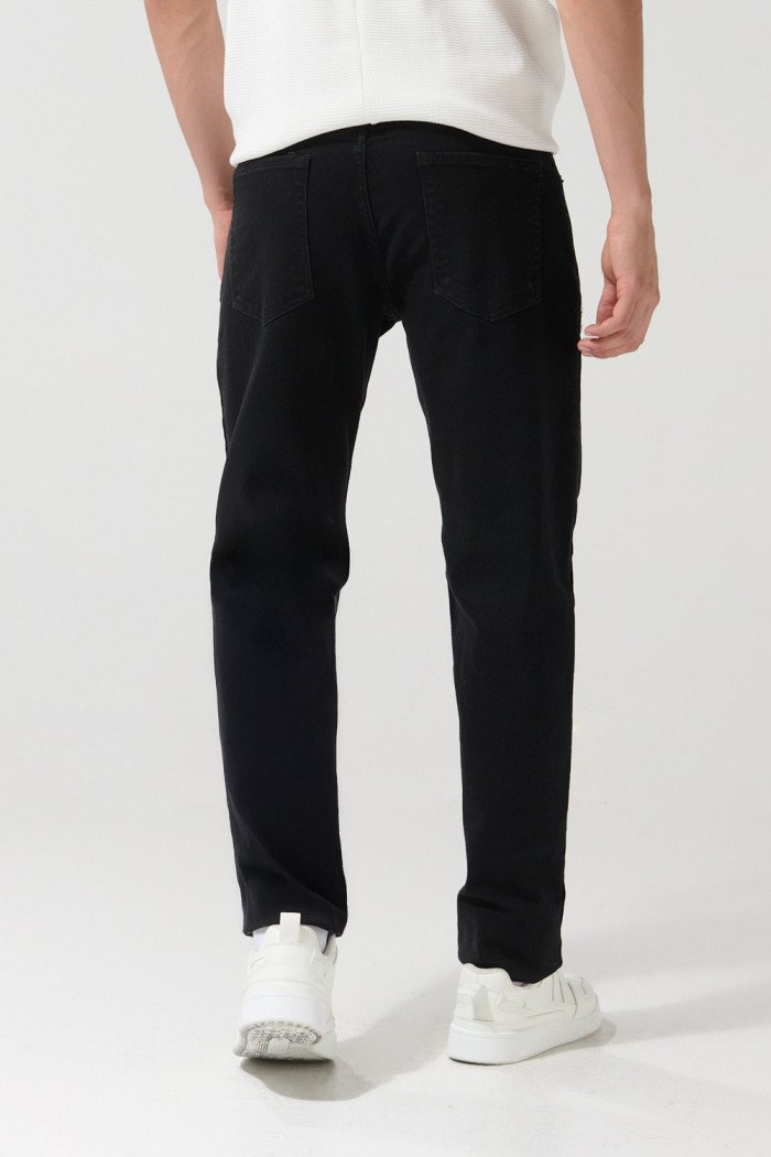 Jean slim negro con ajuste ceñido, cremallera y tiro bajo