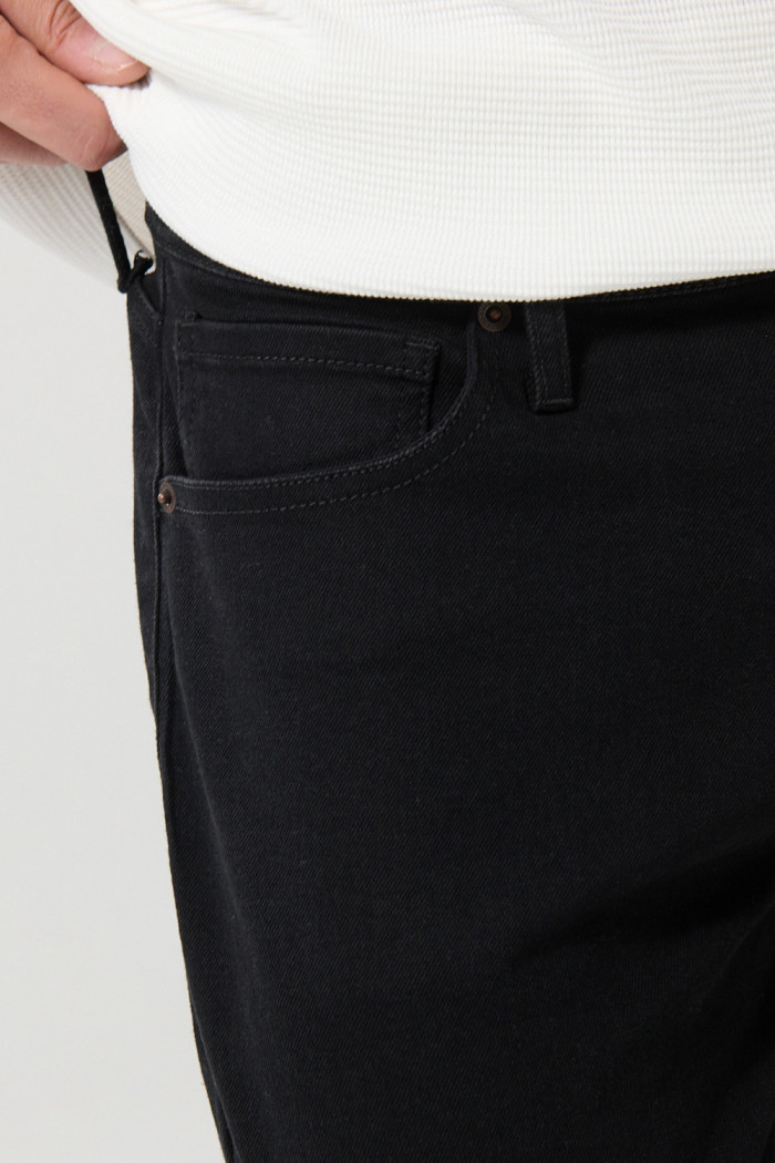 Jean slim negro con ajuste ceñido, cremallera y tiro bajo