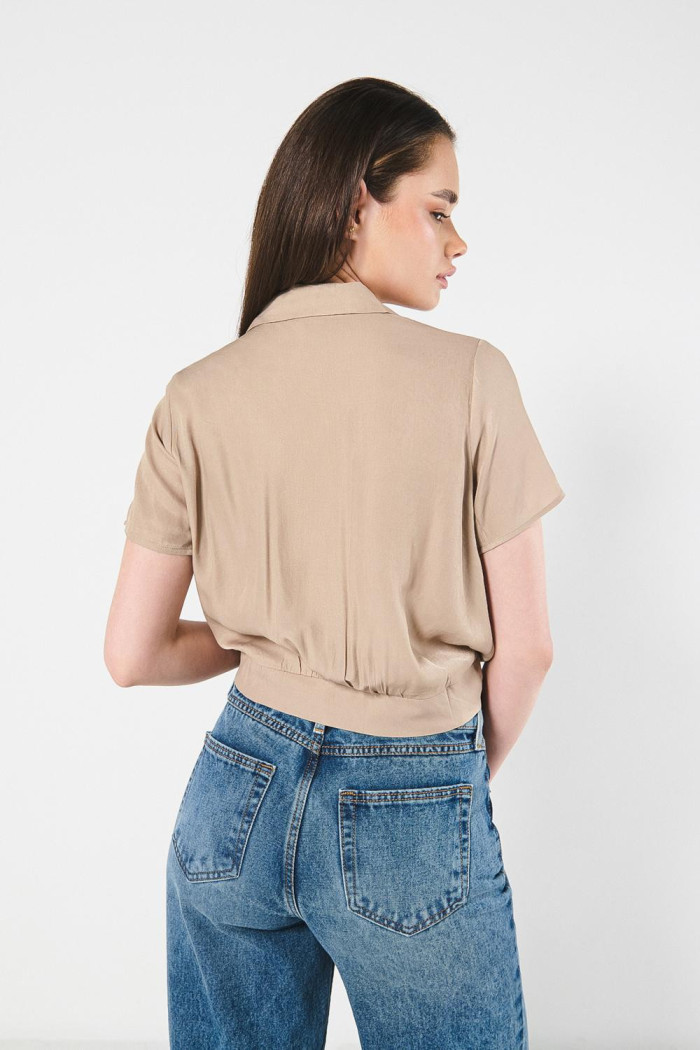 Blusa unicolor con nudo delantero y manga corta