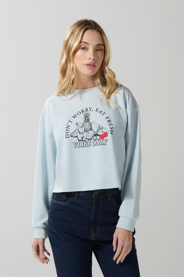 Buzo crop top unicolor con diseño de frutas
